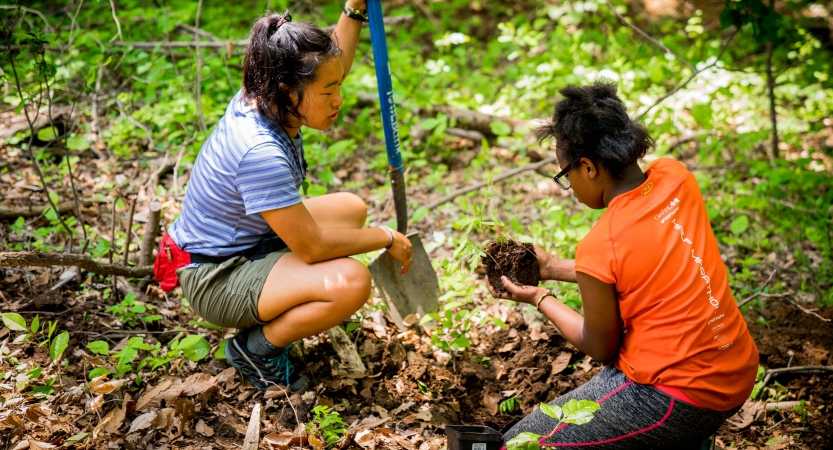 Young people use gardening tools during a service day with Outward Bound. 